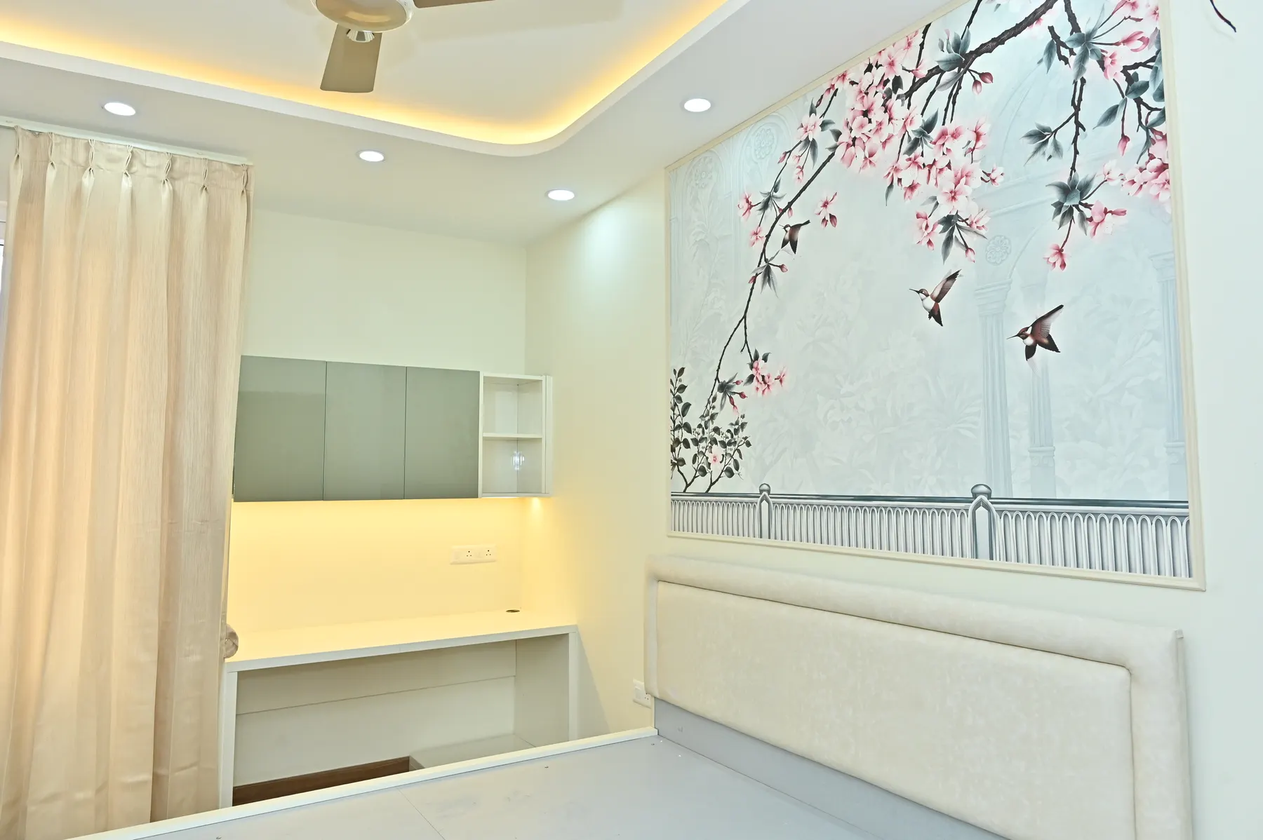 Bedroom with cherry blossom feature wall and study nook designed by Nook & Kove in Bengaluru